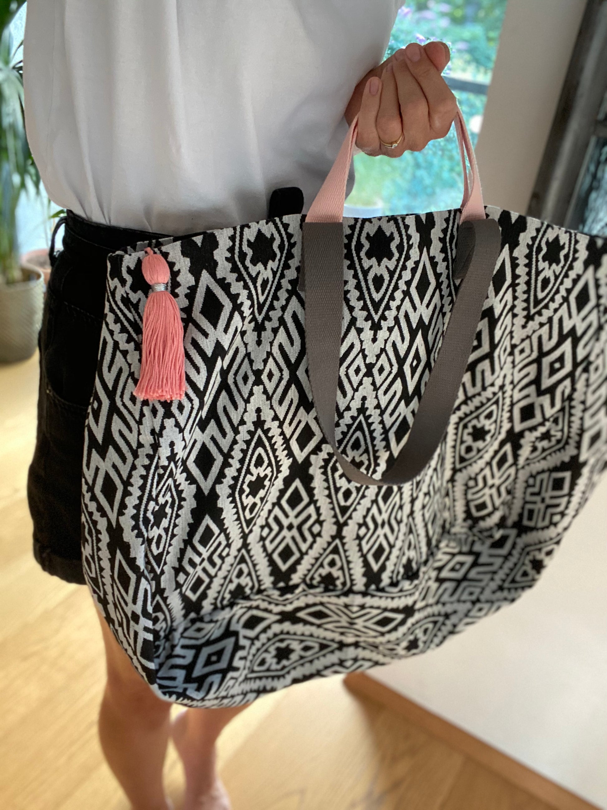 XL Shopper Grafisches Muster mit langen Trägern in Dunkelgrau und kurzen Trägern in Rosé. Der Reißverschluss der Innentasche mit dazu abgestimmter Quaste (hier außen getragen) ist ebenfalls im Farbton Rosé gewählt.